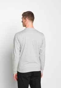Lys grå sweatshirt med lange ærmer, ribbede manchetter og kant, lavet af blødt bomuldsblandingsstof, med rund halsudskæring.