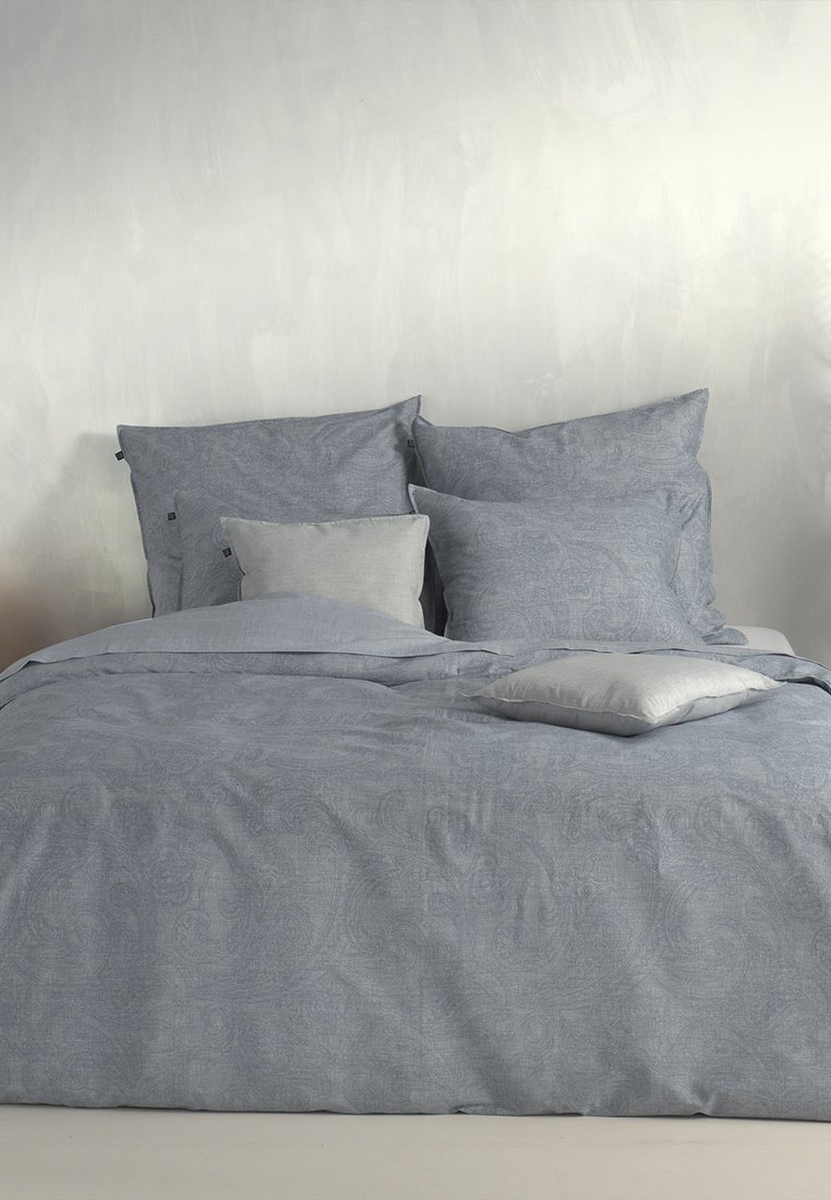 Ensemble de literie en bleu clair avec des motifs paisley complexes. Comprend quatre oreillers de tailles variées, avec une finition en tissu texturé et doux.