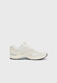 Scarpa atletica bianca realizzata in mesh e suede, con un design testurizzato, punta rotonda, chiusura con lacci e suola in gomma nera a contrasto.