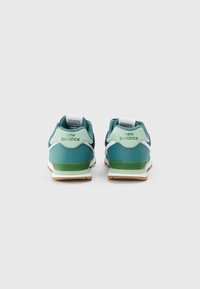 Tumesinine ja helesinise New Balance'i spordijalatsite paar, vaadatuna tagant, valgel taustal.