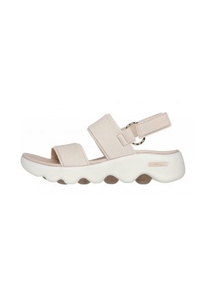 Sandalia beige con punta abierta, dos tiras anchas y suela blanca gruesa y ondulada, con una correa trasera ajustable con hebilla circular.