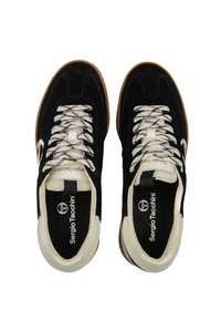 Sneakers in suede nero con accenti crema, suola in gomma marrone e lacci a fantasia con design in bianco e nero. Logo visibile sulla linguetta.