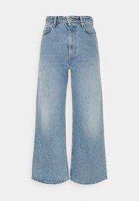 Jean large taille haute bleu clair avec bouton à l'avant, fermeture éclair et design classique à cinq poches sur fond blanc.