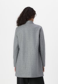 Grijze wolmix jas met een rechte silhouet, lange mouwen en een minimalistisch ontwerp. De achterkant toont een hoge kraag en geen zichtbare sluitingen.