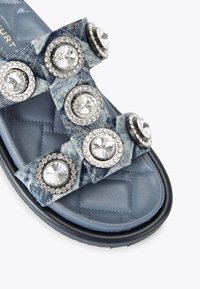Ciabatta in denim con suola imbottita in pelle blu trapuntata, che presenta dettagli con accenti circolari gioiello sulle cinghie in tessuto.