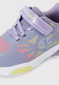 Chaussure de sport violette avec une tige en mesh présentant des motifs abstraits colorés, des accents réfléchissants et une semelle en caoutchouc blanche avec des détails jaunes.