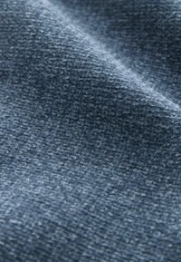 Mėlyna tekstūra audinys su minkštu, audiniu baigtu paviršiumi ir šiek tiek blizgesio, turinti nuoseklų raštą visame paviršiuje.