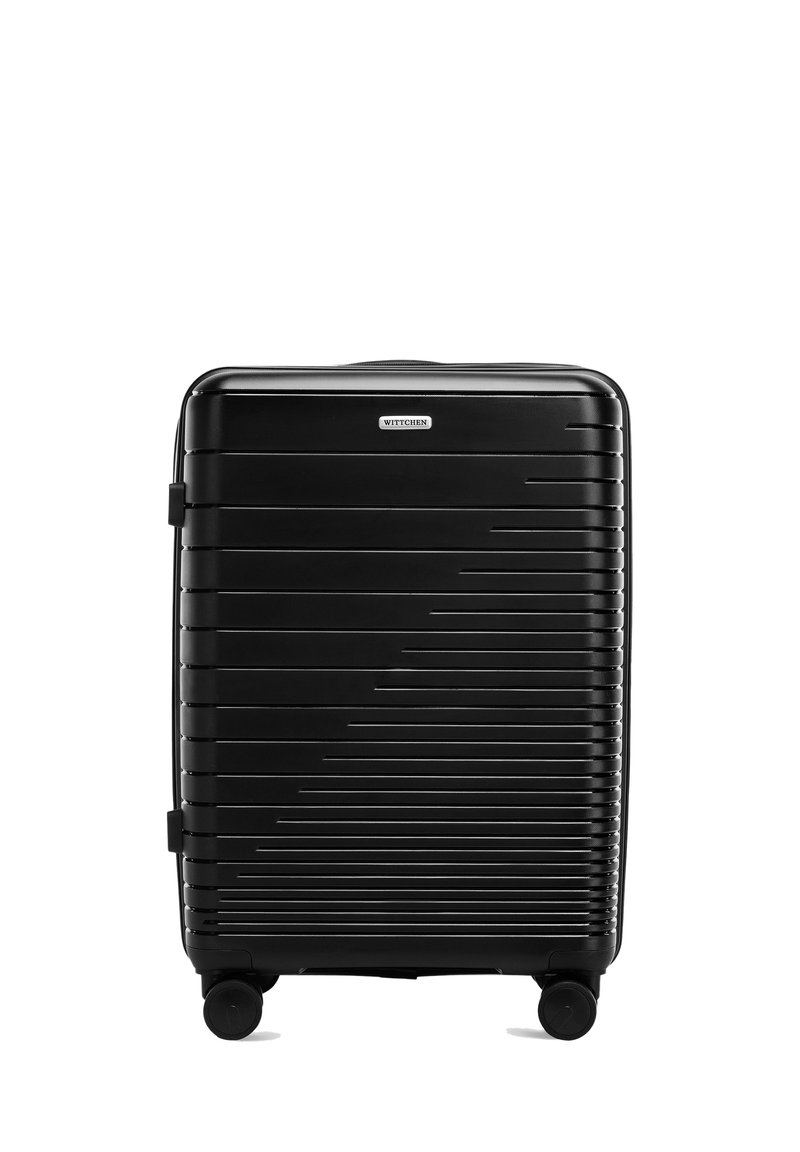 Valise rigide noire avec des lignes horizontales, dotée d'une texture lisse, d'une poignée télescopique et de quatre roues pour une mobilité facile.