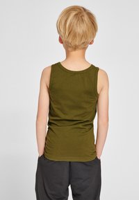 Oliën groene mouwloze tanktop gemaakt van zachte katoen. Heeft een ronde halslijn en een aansluitend ontwerp, met zichtbare naaddetails aan de achterkant.