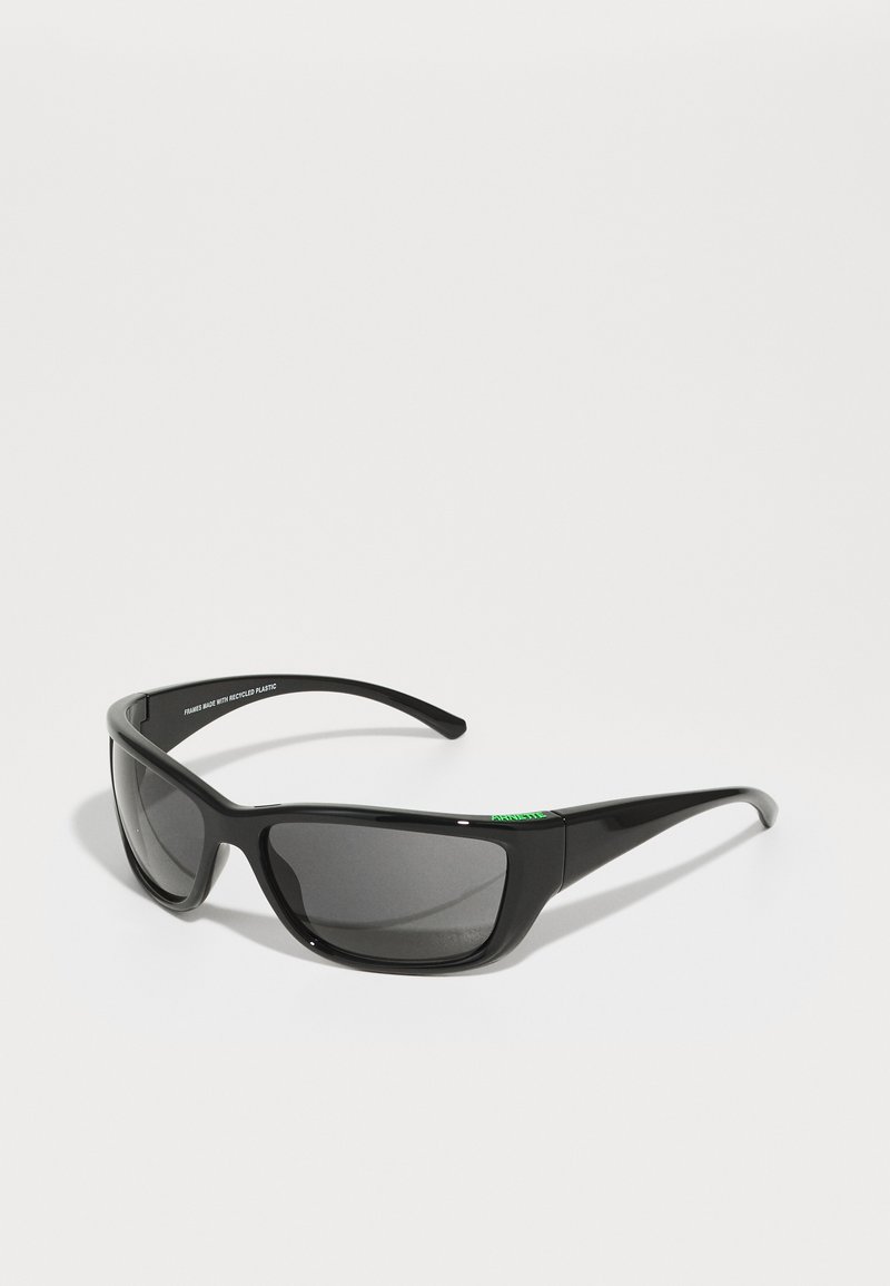 Black sunglasses with rectangular lenses, made from reflective plastic. Features green logo accents on the frame.