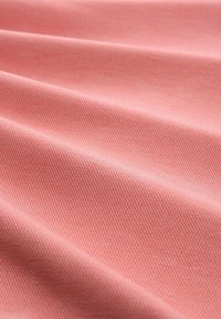 Helles pinkes Gewebe mit einer feinen, strukturierten Webart, die glatte, gefaltete Schichten zeigt und sanfte Wellen im Material erzeugt.