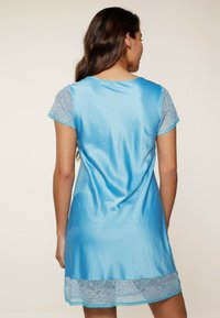 Abito in satin blu cielo con maniche corte in pizzo, una texture liscia e un bordo in pizzo sull'orlo, caratterizzato da una vestibilità comoda e un collo rotondo.