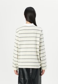 Long-sleeve striped shirt in gray, yellow, and white. Features a classic collar and a relaxed fit. Material appears soft and textured.
