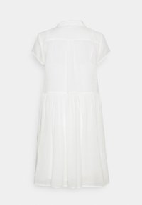 Robe blanche à manches courtes avec un col, taille froncée et jupe ample et fluide vue de dos.
