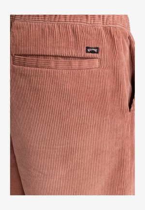 Spodnie z korduroy w miękkim, przykurzonym różowym kolorze z pionowymi paskami, posiadające tylną kieszeń oraz małą markową metkę.