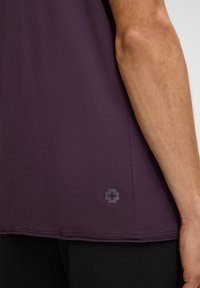 Paarse kortemouwshirt van zachte stof. Voorzien van een discrete logo aan de onderkant en een rechte snit aan de zoom.