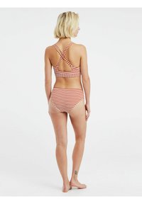 Crvena i bijela prugasta dvodijelna bikini kostim s halter gornjim dijelom s križnim naramenicama i visokim donjim dijelom, izrađen od rastezljivog plivališta.
