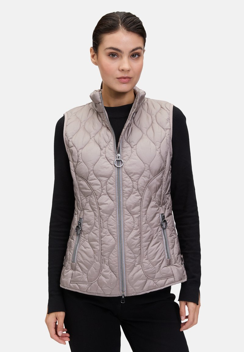 Gequilted, licht taupe vest met hoge kraag, voorrits en twee ritszakken aan de zijkant. Heeft een gestructureerd patroon en een slank ontwerp.