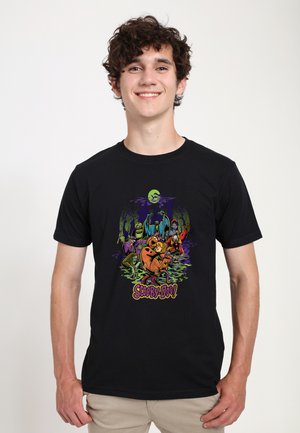 Černé tričko s barevným motivem Scooby-Doo, postavy na strašidelném pozadí, kulatý výstřih, krátké rukávy a standardní střih.