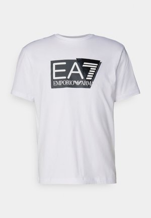 T-shirt bianca in cotone con un logo grafico nero "EA7 EMPORIO ARMANI" dai bordi netti e finitura lucida, centrato sulla parte anteriore.