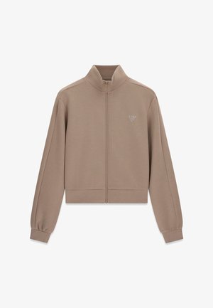 Taupe-farbene Jacke mit Reißverschluss, Stehkragen, langen Ärmeln, gerippten Bündchen und Saum sowie kleinem dreieckigem Logo auf der linken Brust.