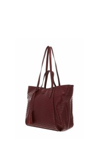 Sac fourre-tout en cuir grenat avec texture matelassée, double poignée et un accent de pampille. Design spacieux adapté à une utilisation quotidienne.