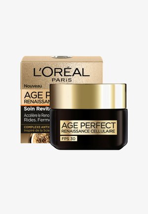 Pot noir avec des accents dorés, étiqueté "AGE PERFECT RENAISSANCE CELLULAIRE FPS 30". Comprend une boîte dorée avec un motif texturé.