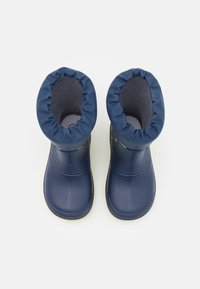 Une paire de bottes d'hiver imperméables bleu marine avec un doublure en tissu rembourré et respirant, et des orteils arrondis, vues de dessus sur un fond blanc.