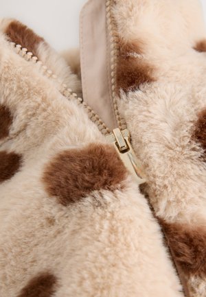 Valekunstnahast jakk kreemika ja pruunika laigulise mustriga, millel on kuldne tõmblukk ja tekstuurse, pehme pinnaga.