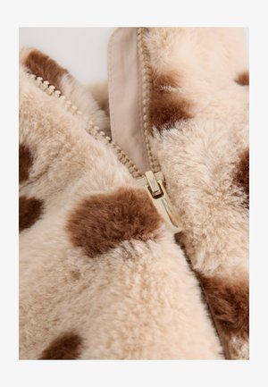 Dirbtinio kailio striukė su kreminės ir rudos spalvos dėmėtu raštu, su auksiniu užtrauktuku ir tekstūruota, minkšta paviršiaus danga.