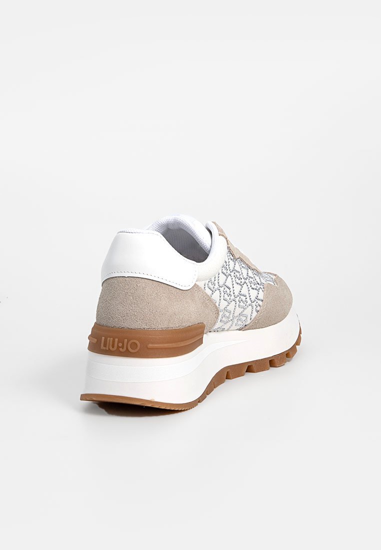 Sneaker in suede beige e pelle bianca con pannello laterale testurizzato, design senza lacci e suola in gomma marrone con il nome del marchio.