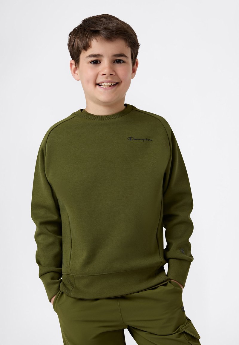 Olivgrön sweatshirt med ribbad textur, rund halsringning och Champion-logotyp på bröstet. Elastiska muddar och avslappnad passform.