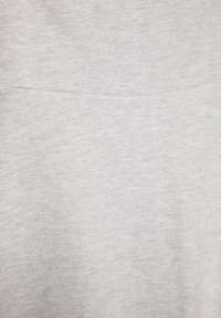 Tissu en coton gris clair avec une surface douce et légèrement texturée ; présente un design simple et dépouillé sans motifs ni accents visibles.