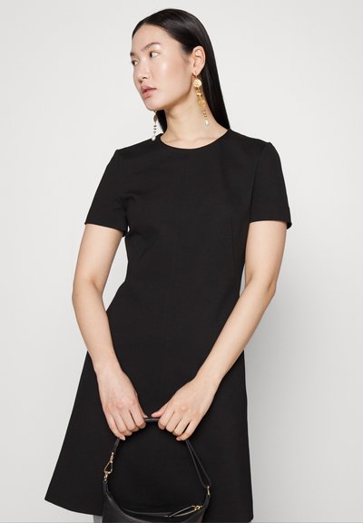 Robe noire à manches courtes avec un buste ajusté et une jupe évasée ; texture lisse ; présente un col rond et des détails de coutures.