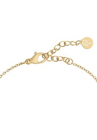 Gold chain bracelet featuring a lobster clasp and adjustable links. Notable round tag with engraved design attached to the chain.