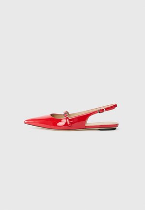 Zapato slingback de charol rojo con punta afilada, pequeña correa de acento con un detalle circular y suela plana. Textura suave, diseño elegante.