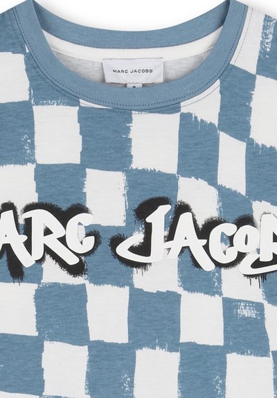 Chemise à carreaux bleue et blanche avec un motif de coups de pinceau et un texte blanc audacieux "Marc Jacobs" souligné en noir sur la poitrine.