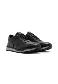 Sneaker in pelle nera con finitura liscia, design con lacci, colletto imbottito e suola in gomma con dettagli testurizzati.