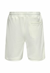 Un short en maille blanche présente une taille élastique, une seule poche arrière et une texture respirante avec de petites perforations sur l'ensemble.