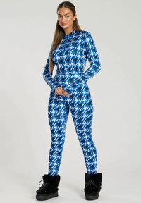 Blauw houndstooth-patroon jumpsuit met lange mouwen, ritskraag, aansluitend ontwerp en zachte stof; gecombineerd met zwart bontgevoerd enkellaarsjes.