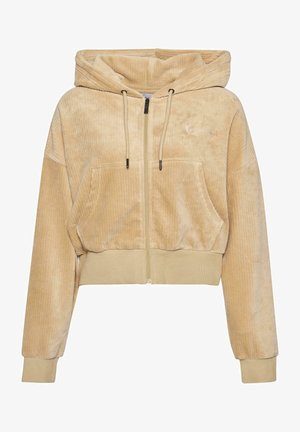 Avkortad zip-up hoodie i mjuk beige kordfloret. Har en huva, två framfickor och elastiska muddarn med en diskret logodetalj.