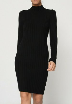 Robe noire côtelée à manches longues et col montant ; silhouette ajustée avec un tissu texturé et une longueur jusqu'au genou.