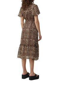 Leopardprint, semi-doorzichtige midi-jurk met korte fladdermouwen, een strakke taille en een gelaagde zoom, gecombineerd met zwarte platformsandalen.