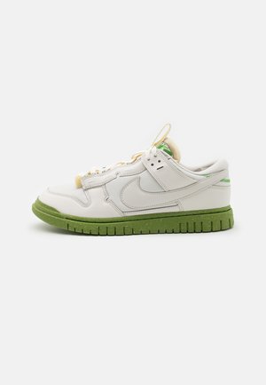 Biało-jasnozielony niski sneaker Nike z teksturowaną podeszwą, cholewką z siateczki i skóry oraz widocznym logo Swoosh po boku.
