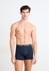 Boxer- shorts bleu marine en tissu doux avec une taille élastique portant le nom de la marque "BJOR Borg" en lettres blanches.