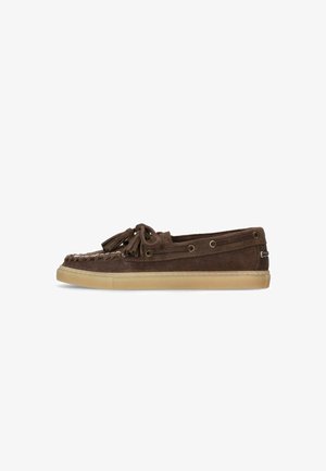 Mocassin en daim marron avec pompons, détail en dentelle et semelle en caoutchouc beige, présenté en profil latéral sur fond blanc.
