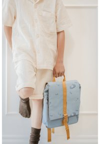 Zaino azzurro chiaro con cinghie gialle, decorato con un motivo di cavallucci marini e bolle d'acqua. Tessuto liscio, forma rettangolare, tasca laterale visibile.