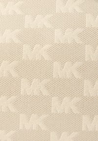 Bežīgs audums ar teksturētu rakstu, kas ietver atkārtoti viegli reljefno "MK" logotipu. Materiāls ir ar austas izskatu, piešķirot vizuālu dziļumu.