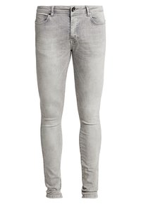 Jeans de mezclilla ajustados en tono gris claro con botón frontal y cremallera, diseño de cinco bolsillos y un ligero desgaste en los muslos y las rodillas.