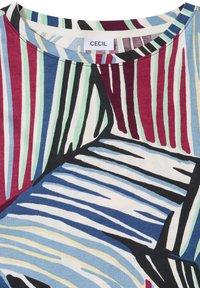 T-shirt col rond avec des rayures verticales et diagonales en bleu, vert, rouge, noir, blanc et jaune, marqué de la marque « CECIL ».